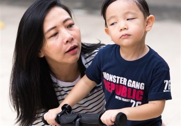 adult teaching child to ride bike